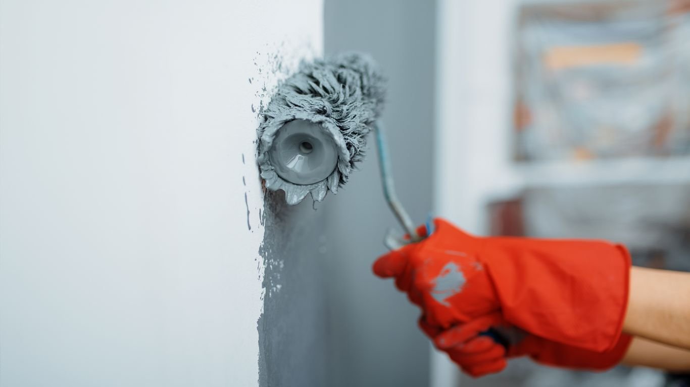 A worker applying fresh paint to a wall, demonstrating the skills of commercial painting contractors for quality home renovations.