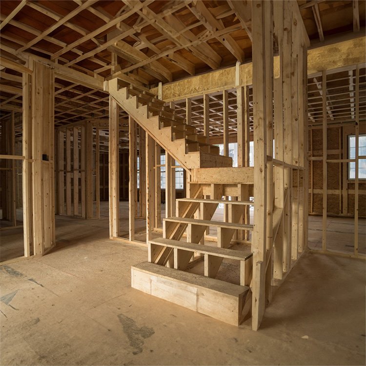 Framing work in progress showcasing a newly constructed staircase, emphasizing structural details in home construction.