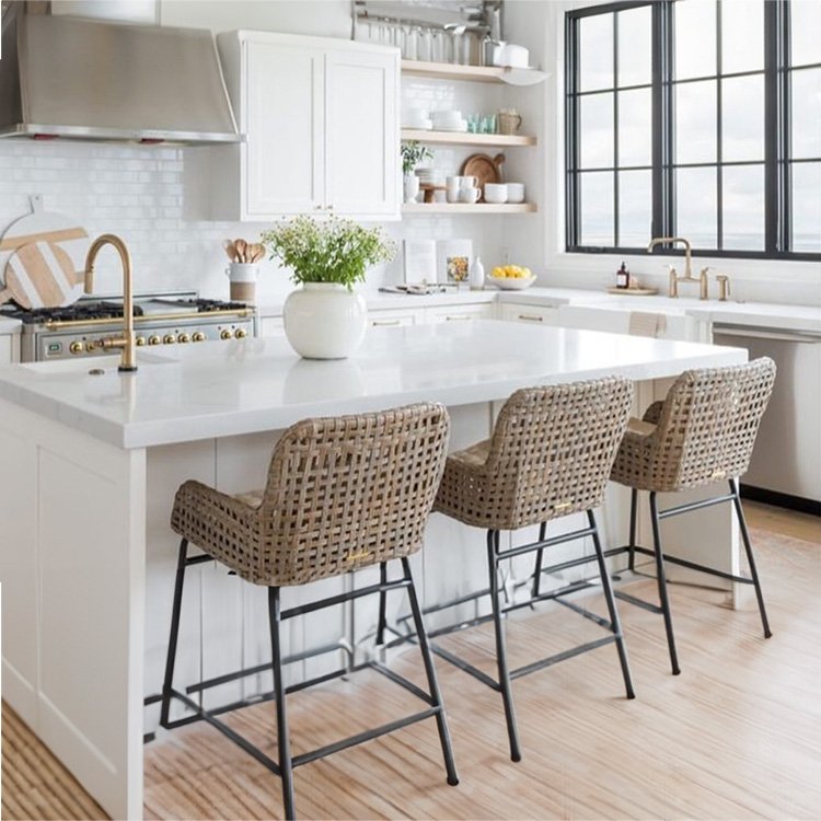 A beautifully designed kitchen featuring a modern island with three stylish woven bar stools. The elegant white cabinetry and marble countertops highlight Duluth Construction's expertise in home renovation and interior design, showcasing our commitment to quality craftsmanship in Washington and Oregon. Ideal for families and entertaining, this kitchen exemplifies the perfect blend of functionality and aesthetics in home improvement projects.