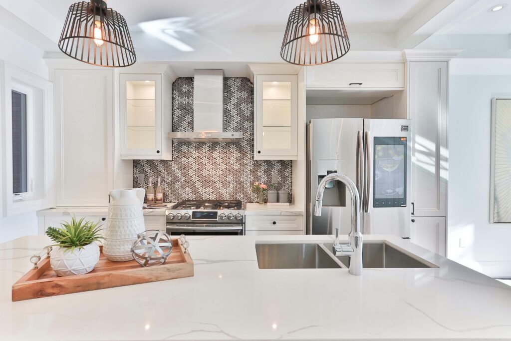 Modern kitchen featuring white cabinetry, a sleek backsplash, stainless steel appliances, and a spacious marble island. Duluth Construction specializes in kitchen remodeling, custom cabinetry, and high-end finishes for a stylish and functional home.