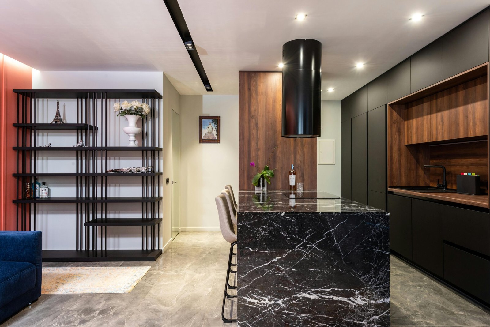 Luxury modern kitchen renovation by Duluth Construction featuring a sleek black marble island, wood accents, and custom cabinetry for a stylish and functional space.