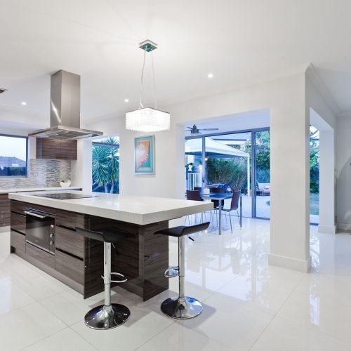 Modern open-concept kitchen by Duluth Construction featuring a sleek quartz countertop island, custom cabinetry, and stylish lighting upgrades.