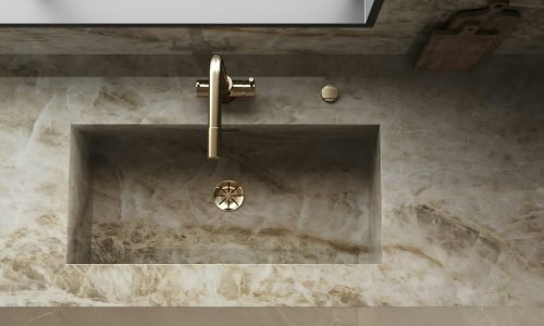 Luxurious marble kitchen sink with a gold faucet, seamlessly integrated into a custom countertop design by Duluth Construction.