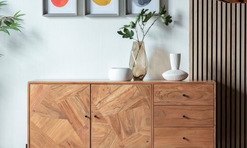 Modern wooden sideboard with geometric panel design, complemented by minimalist decor and artwork. Duluth Construction specializes in custom carpentry, furniture design, and high-quality woodworking to elevate interior spaces.