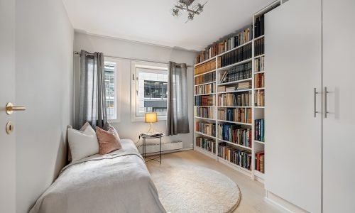 Cozy home library with a built-in bookshelf, soft lighting, and modern interior design. Duluth Construction specializes in interior painting and custom finishes to create elegant and inviting spaces.