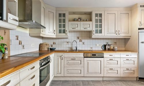 Modern kitchen with custom cabinetry, wood countertops, and tiled backsplash designed by Duluth Construction. Expert kitchen remodel for style and functionality.