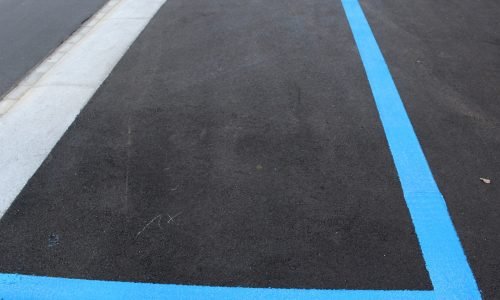 Freshly painted blue parking lines on asphalt, showcasing professional exterior painting and marking services. Duluth Construction delivers high-quality painting solutions for commercial and residential projects.