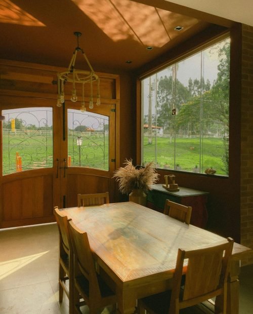 Rustic dining room with custom window solutions by Duluth Construction, featuring energy-efficient windows and elegant wood doors for a warm and inviting space.