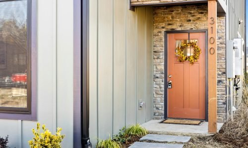 Modern home entrance featuring metal siding installation with stone veneer accents. Duluth Construction specializes in durable metal siding solutions, enhancing curb appeal with weather-resistant and energy-efficient materials.