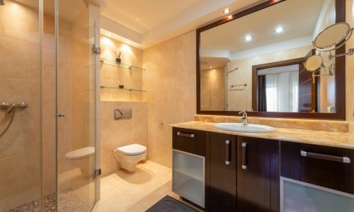 Elegant bathroom remodel by Duluth Construction featuring custom tile work, glass shower enclosure, modern vanity, and upgraded lighting for a luxurious finish.