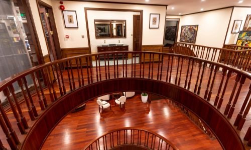 Elegant interior with a grand curved wooden staircase, polished hardwood flooring, and intricate railing details. Duluth Construction specializes in custom carpentry, stairway installation, and high-end interior finishes for luxury homes.