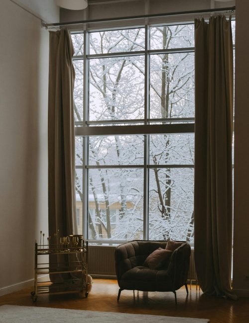 Elegant living space featuring energy-efficient windows with custom window treatments by Duluth Construction, enhancing insulation and aesthetics.