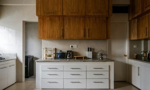 Modern kitchen with custom wood cabinetry and sleek white drawers, featuring a granite countertop and built-in storage. Duluth Construction specializes in cabinetry installations and kitchen remodeling, ensuring high-quality craftsmanship and functional design.