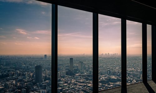 Expansive floor-to-ceiling windows offering a breathtaking city skyline view, showcasing energy-efficient window installation by Duluth Construction.