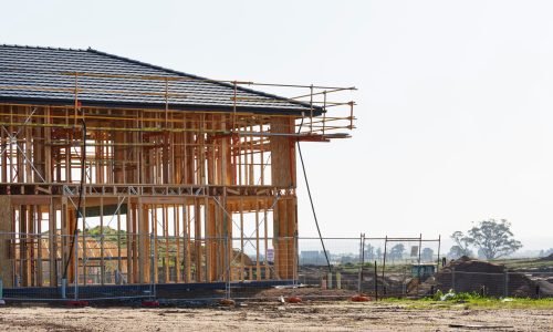 Wood-framed house under construction with scaffolding, showcasing framing near me, custom carpentry, and home remodelers services by Duluth Construction for high-quality home building and renovations.