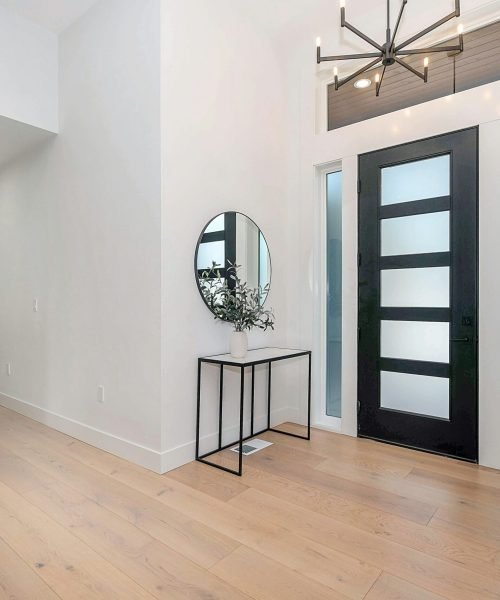 Modern black entry door with frosted glass panels and sidelights, enhancing natural light in a contemporary home. Duluth Construction specializes in custom entry door installation, repair, and replacement, providing high-quality craftsmanship for residential and commercial properties.